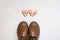 Top view of brown leather boots and two broken heart gingerbread cookies decorated with pink glaze with the message love stinks on