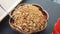 Top view of brown wooden bowl full of cooked cereal with spoon put in it.