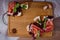 Top view on bruschetta sandwiches with jamon, tomatos and green sprouts on wooden board.