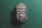 Top view of buddha head statue on green background