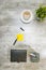 Top view of business desk with coffee, potted plant, notebook, notes paper and business accessories