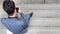 Top view of business man uses hand a smartphone and sits at stair pedestrian