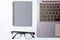 Top view of business working place with notepad,modern glasses,keyboard on white table,flatlay concept