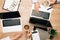 Top view of businesspeople with coffee, laptops and dollar banknotes on table