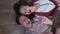 Top view Caucasian husband and wife grimacing taking selfie on smartphone lying on parquet floor. Carefree couple having