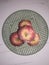 Top view center ,red apple surrounded by apples on green plastic porous plate