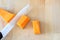 Top view of a ceramic knife cutting cubes a pumpkin