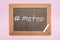 Top view of chalk on chalkboard with written hashtag me too isolated on pink.