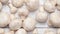 Top view of champignon mushrooms on white wooden table background, pan shot