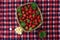 top view of a checkered picnic blanket with strawberries