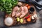 Top view of chicken breasts, soy sauce, mushrooms, tomatoes, lemon, chili, pepper, salt and parsley on a rustic wooden