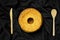 Top view of Chiffon cake on wooden board and wooden cutlery on black satin background