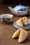 Top view of Chinese fortune cookies, teapot and cup, on wooden table, with selective focus