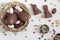 Top view of chocolate eggs and easter almonds, chocolate rabbits and other sweets on white wooden table