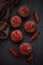 Top view on chocolate muffins decorated red currant berries on dark wooden background. Flat lay. Soft focus