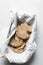 top view of chocolate stuffed cookies on a napkin, vanilla and chocolate cookies in a tin