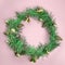 Top view on Christmas composition with wreath made from tree pine or spruce branches with cones and toys as decoration. Pink