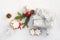 Top view of a christmas gift box in silver wrapping paper over a white fluffy background. A jar full of star cookies and christma