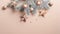 Top view Christmas tree branch with copper color stars and balls over beige background with glitter confetti. Xmas minimal flat