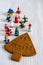 Top view of Christmas tree-shaped gingerbread cookie with figurines, the first ones focused, the others in bokeh, on white backgro
