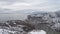 Top view of the city near the sea in winter. Shot. Snowy expanses in the mountainous area near the city