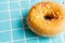 Top view of a classic donut with colored noodles, on a light blue background, horizontally,