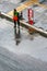 A top view of a cleaner lady sweeping dirty water off the road in Bangkok, Thailand.