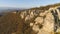 Top view of cliffs in morning sun. Shot. Picturesque panorama of rock and horizon of mountains with blue sky. Beautiful