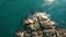 Top view of cliffs, surrounded by green waters and breaking waves