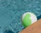 Top view close-up beach ball near swimming pool coping