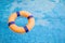 Top view and close up with copy space of orange swim ring for lifeguard and safety on the clear water with ripple wave of the