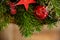 Top view close up green spruce background christmas card with red decoration