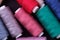 Top view close up of scattered colorful cotton thread coils