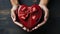 top view of closeup African American male hands holding gift heart shaped box with red bow