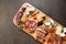 Top view closeup of an assortment of delicious cured meats and cheeses on a wooden board