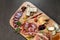 Top view closeup of an assortment of delicious cured meats and cheeses on a wooden board