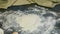 Top view closeup on big heap of wheat flour on dark kitchen table