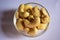 Top View of Closeup Cashew Nuts in a Transparent Glass Bowl On isolated Black Background