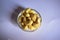 Top View of Closeup Cashew Nuts in a Transparent Glass Bowl On isolated White Background