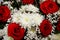 Top view closeup elegant bouquet of large red roses and white velvet daisies