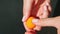 Top view closeup on female hands insert dry clove into small orange marzipan ball