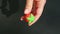 Top view closeup female hands make red strawberry shaped marzipan candy