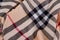 Top view closeup folded beige checked scarf with black, white and red strips