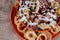 Top view closeup of french fries, ham, onion rings with white sauce on top on an orange spiral plate