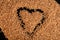 top view closeup heart sign made in big heap of dried coriander seeds