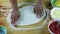 Top view closeup man by hands make pizza dough round and thin on wooden table