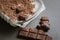 Top view closeup of pieces of dark chocolate on a pile of shredded chocolate on a white plate