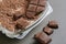 Top view closeup of pieces od dark chocolate on a pile of shredded chocolate on a white plate