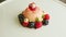 Top view closeup pink icing dessert with bize and berries rotates on plate