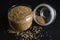 Top View Closeup Sesame Seeds in a Open Transparent Glass jar On isolated Black Background